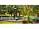 Fun playground area with slides and climbing structures, nestled among mature trees and surrounded by a safety fence at 784 Seneca Trl, St Cloud, FL 34772