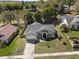 Inviting home with manicured lawn, complemented by mature trees, and a long driveway, from an aerial perspective at 834 High Pointe Cir, Minneola, FL 34715