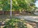 Spacious backyard featuring mature trees, a basketball hoop, and a fenced perimeter for privacy and recreation at 834 High Pointe Cir, Minneola, FL 34715