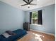 Cozy bedroom with natural light and a ceiling fan; hardwood floors gleam with sunlight at 834 High Pointe Cir, Minneola, FL 34715