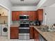 Modern kitchen featuring sleek appliances, ample counter space, and adjacent laundry area at 834 High Pointe Cir, Minneola, FL 34715