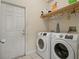 Clean laundry room with a washer, dryer, and a shelf for storage at 834 High Pointe Cir, Minneola, FL 34715