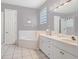 Bright main bathroom with double sink vanity, bathtub, and separate shower at 834 High Pointe Cir, Minneola, FL 34715