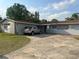 Shows driveway leading to the attached garage with a car parked outside of the modest single-story house at 837 Quintilian Ave, Orlando, FL 32809