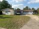 Modest single-story home with a front yard and a concrete driveway leading to an attached garage at 837 Quintilian Ave, Orlando, FL 32809