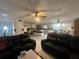 View of the living room featuring tile floors, ceiling fan, and open kitchen area at 837 Quintilian Ave, Orlando, FL 32809