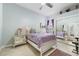 Cozy bedroom featuring neutral walls, tile flooring, mirrored closet, and a charming purple patterned bedspread at 8550 Lost Cove Dr, Orlando, FL 32819