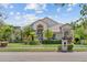 Charming home featuring lush landscaping with tropical plants and a well-maintained green lawn at 8550 Lost Cove Dr, Orlando, FL 32819