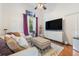 Cozy living room features a plush sofa, modern TV console, and a window with natural light at 8550 Lost Cove Dr, Orlando, FL 32819