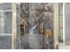 Close up of marble shower with gold hardware and a built in toiletry niche at 8550 Lost Cove Dr, Orlando, FL 32819