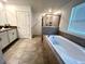 Bathroom featuring a soaking tub, walk-in shower, and granite countertop at 9122 Sommerset Hills Dr, Davenport, FL 33896