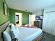 Cozy bedroom with a green accent wall, soft bedding, and a view into another room at 9122 Sommerset Hills Dr, Davenport, FL 33896