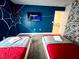 Colorful Spiderman-themed bedroom, featuring twin beds and a flat-screen television for entertainment at 9122 Sommerset Hills Dr, Davenport, FL 33896