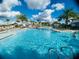 Spacious community pool surrounded by palm trees, lounge chairs, and clear water for a refreshing experience at 9122 Sommerset Hills Dr, Davenport, FL 33896