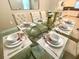 A spacious dining area showcases a glass table set for six, blending elegance and functionality at 9122 Sommerset Hills Dr, Davenport, FL 33896