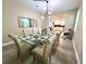 An elegant dining room with a glass table seats eight, open to the kitchen for seamless entertaining at 9122 Sommerset Hills Dr, Davenport, FL 33896