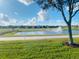 Scenic golf course view with a water feature, sand traps, and well-maintained green fairways surrounded by beautiful homes at 9122 Sommerset Hills Dr, Davenport, FL 33896