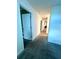 A long hallway with neutral tones, carpeted flooring, and modern lighting at 9122 Sommerset Hills Dr, Davenport, FL 33896
