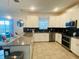 Modern kitchen with white cabinets, a large island, stainless steel appliances, and tile flooring at 9122 Sommerset Hills Dr, Davenport, FL 33896