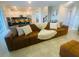 Open-concept living room showcasing a large sofa, kitchen with counter seating, and modern design at 9122 Sommerset Hills Dr, Davenport, FL 33896