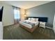 A well-lit primary bedroom features a plush bed, stylish headboard, and neutral decor for ultimate relaxation at 9122 Sommerset Hills Dr, Davenport, FL 33896