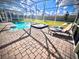 Screened-in pool and spa area with lounge chairs and well-manicured lawn at 9122 Sommerset Hills Dr, Davenport, FL 33896