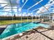 Sparkling in-ground pool with attached spa inside screened enclosure, perfect for year-round enjoyment at 9122 Sommerset Hills Dr, Davenport, FL 33896