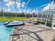 Relaxing spa with sun loungers poolside, set within a screened lanai and lush landscaping at 9122 Sommerset Hills Dr, Davenport, FL 33896