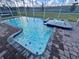 A refreshing in-ground pool with a connecting spa inside a screened in enclosure at 9122 Sommerset Hills Dr, Davenport, FL 33896