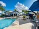 Inviting poolside area featuring a bar, seating, and umbrellas, offering a perfect spot for socializing and relaxation at 9122 Sommerset Hills Dr, Davenport, FL 33896