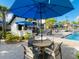 Charming poolside setting with outdoor seating, umbrellas, and lush landscaping for a relaxing experience at 9122 Sommerset Hills Dr, Davenport, FL 33896