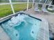 A rejuvenating hot tub with lounge chairs inside of a screened in patio at 9122 Sommerset Hills Dr, Davenport, FL 33896