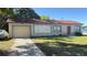 Charming single-story home featuring a front yard, driveway, and attached one-car garage at 100 Avenue K Ne, Winter Haven, FL 33881