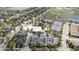 Aerial view featuring a pool, parking area, clubhouse and tennis courts, surrounded by homes and green spaces at 10731 Belfry Cir, Orlando, FL 32832