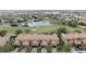 Aerial view of townhomes with golf course and pond featuring tile roofs and brick driveways at 10731 Belfry Cir, Orlando, FL 32832