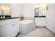 Bright bathroom featuring dual vanities, tile flooring, and a soaking tub at 10731 Belfry Cir, Orlando, FL 32832