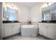 Bright bathroom featuring dual vanities, tile flooring, and a soaking tub at 10731 Belfry Cir, Orlando, FL 32832