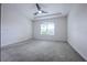 Bright bedroom featuring a trey ceiling, ceiling fan, carpet flooring and a large window at 10731 Belfry Cir, Orlando, FL 32832