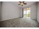 Bedroom featuring neutral carpet, ceiling fan and sliding glass doors to the outside balcony at 10731 Belfry Cir, Orlando, FL 32832