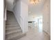 Bright entryway with tiled floors, staircase and adjacent open concept dining and living areas at 10731 Belfry Cir, Orlando, FL 32832