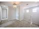 Bright hallway features plush carpet, a crystal chandelier, and access to multiple rooms at 10731 Belfry Cir, Orlando, FL 32832