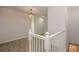 Hallway featuring a chandelier, carpet flooring, and white railings at 10731 Belfry Cir, Orlando, FL 32832