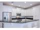 Modern kitchen featuring white cabinets, stainless steel appliances, and a breakfast bar with granite countertops at 10731 Belfry Cir, Orlando, FL 32832
