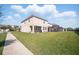 Expansive backyard featuring lush lawn, patio area and partial view of a screened lanai at 1107 Trappers Trail Loop, Davenport, FL 33896