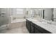 Bright bathroom with a soaking tub, a separate tiled shower and double sink vanity at 1107 Trappers Trail Loop, Davenport, FL 33896