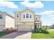 Two-story home boasts a paver driveway, two-car garage, and well-manicured lawn at 1107 Trappers Trail Loop, Davenport, FL 33896