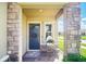 Inviting front porch with stone columns, elegant door, and charming decor at 1107 Trappers Trail Loop, Davenport, FL 33896