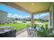 Relaxing covered patio featuring dining area with outdoor furniture and grill for enjoyment at 1107 Trappers Trail Loop, Davenport, FL 33896