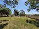 Expansive green backyard with a wooden fence and mature trees offering a serene view at 133 La Casa # 133, Lake Wales, FL 33898