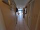 Hallway featuring neutral walls, tile flooring, and a view leading to a brighter living area at 133 La Casa # 133, Lake Wales, FL 33898
